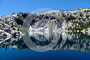 Granite rocks and reflections in calm water.