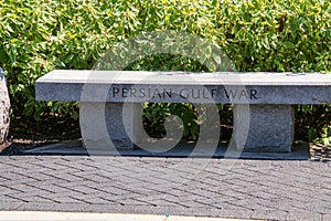 Granite stone bench with the words Persian Gulf War chiseled into the edge of the seat.