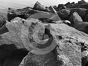 Granite stones on the seashore. Black-and-white photo. Contrasting, good texture.