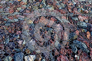 Granite stones under the grate. Pattern, background. Landslide protection