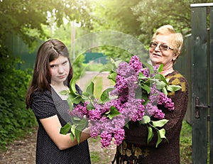 Grannie and grand daughter with lilac violet flowers photo