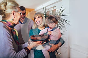 Granny brings a cake to grandchildren