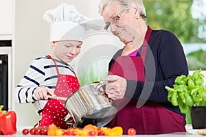 Granny cooking together with her grandson