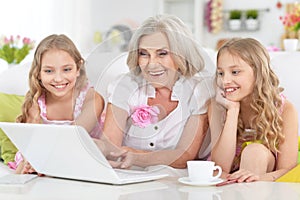Granny with granddaughters using laptop