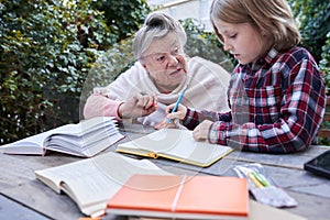 Granny helping to grandson with the homework