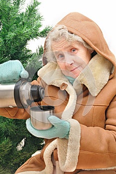 Granny with hot tea under fir