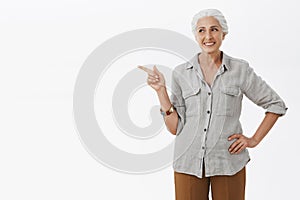 Granny knows something. Portrait of joyful and delighted happy self-assured senior woman with white hair holding hand on