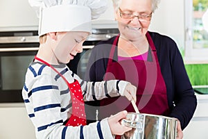 Granny and little boy preparing food in kitchen