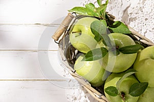 Granny Smith apples in basket. Fresh green fruit on rustic white background