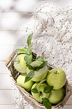 Granny Smith apples in basket. Fresh green fruit on rustic white background