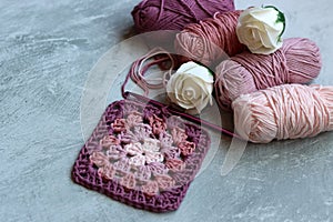 Granny square pattern crocheted of pink cotton yarn. Arts and crafts