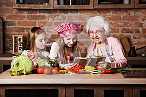 Granny with two granddaughters reading recipe