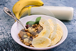 Granola with banana and milk on the table. Close-up. Delicious and healthy breakfast.