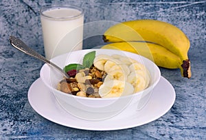 Granola with banana and milk on the table. Top view. Delicious and healthy breakfast.