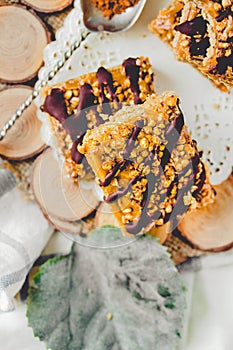 Granola bar cake with date caramel and chocolate. Healthy sweet dessert snack. Cereal granola bar with nuts, fruit and berries on