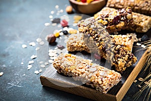 Granola bar with nuts, fruit and berries on black.