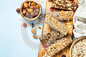 Granola bar with nuts, fruits and berries on blue.
