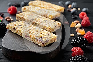 Granola bar with raisins, on black wooden table