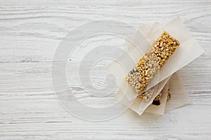 Granola bars on baking sheet over white wooden background, top view.