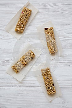 Granola bars on baking sheet over white wooden surface, overhead view. Flat lay, top view, from above.