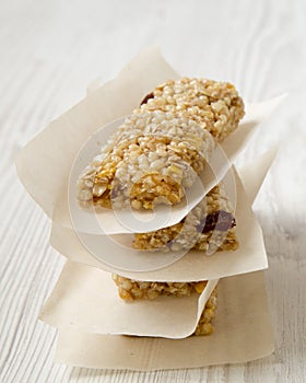 Granola bars on baking sheet over white wooden surface, side view.