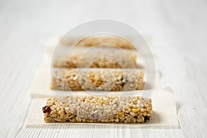 Granola bars on baking sheet over white wooden surface, side view. Close-up. Selective focus
