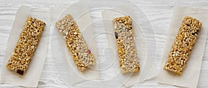 Granola bars on baking sheet over white wooden surface, top view