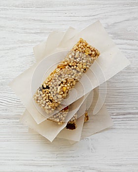 Granola bars on baking sheet over white wooden surface, top view. Overhead