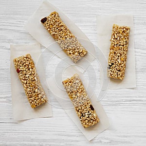 Granola bars on baking sheet over white wooden surface, top view. Overhead, flat lay