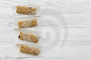 Granola bars on baking sheet over white wooden surface, top view.