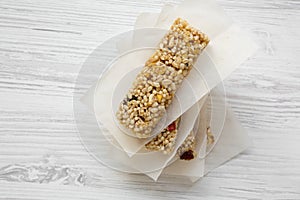 Granola bars on baking sheet over white wooden table, overhead view.