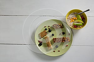 Granola bars and fruit cereal on white background