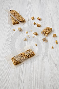 Granola bars over white wooden table, high angle.