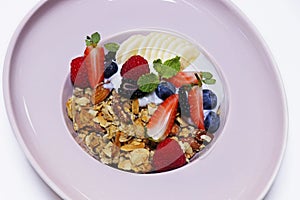 granola bowl with yogurt, banana and fresh assorted berries. healthy breakfast concept