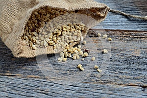 Granola in Burlap Sack Spilling onto Wood Background