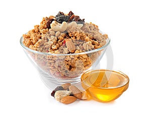 Granola with dried fruits and nuts in bowl and sweet honey on white background