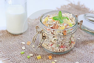 Granola with dried fruits, pieces of zucatam, nuts in a glass jar