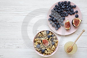 Granola with fruits and honey over white wooden surface, top view. Flat lay, from above, top view