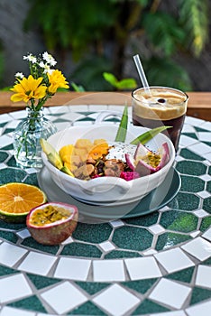 Granola with greek yogurt, honey, fresh fruits, chia seeds served with ice americano