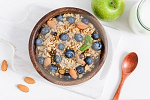 Granola, milk and green apple on old white table. Healthy breakfast food