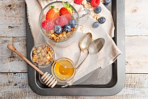 Granola with nuts, yogurt and red fruits berries in a jar. Breakfast parfait with muesli, yoghurt, red fruits berries and honey,
