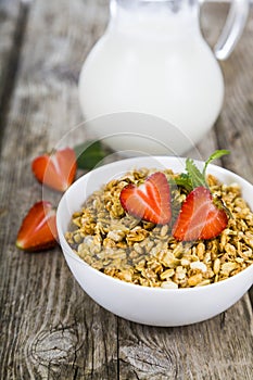 Granola with strawberry and a jug of milk