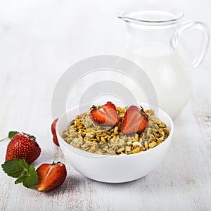 Granola with strawberry and a jug of milk