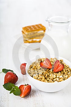 Granola with strawberry and a jug of milk