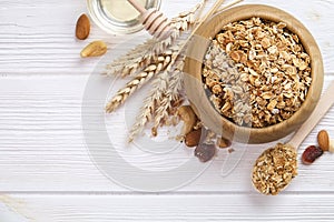 Granola superfood with almond and cashew nuts, dry fruits, raisins cherry in wooden bowl on the white wooden table, top view, brig