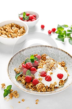 Granola with white plain yogurt and fresh raspberry in a bowl, healthy food for breakfast