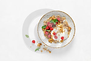 Granola with white plain yogurt and fresh raspberry in a bowl, healthy food for breakfast, top view