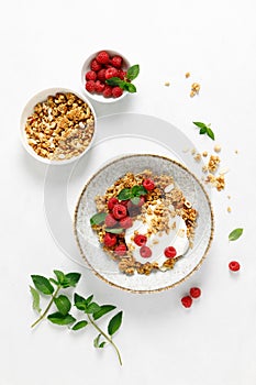 Granola with white plain yogurt and fresh raspberry in a bowl, healthy food for breakfast, top view