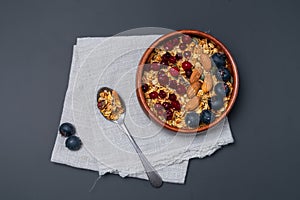 Granola in a wooden bowl with berries and almonds.