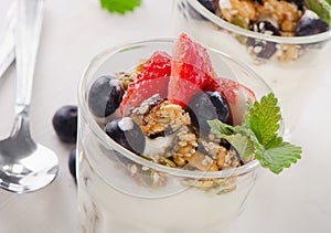 Granola with yogurt and berries in glasses.